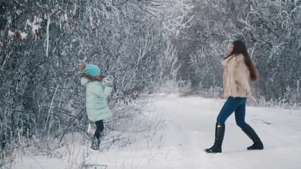 Mamá e hija lanzan bolas de nieve — Vídeos de Stock