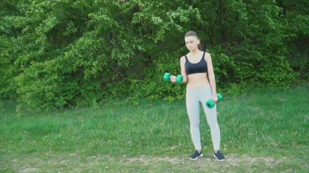 La chica está haciendo ejercicio con una mancuerna — Vídeo de stock