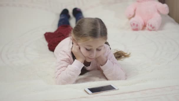 Дівчина дивиться в телефон — стокове відео