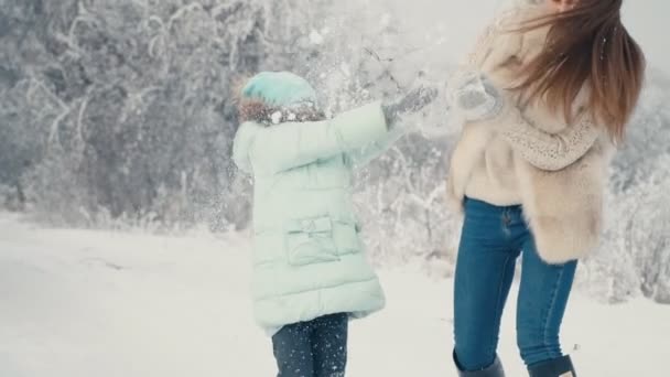 Мама и дочь бросают снежки — стоковое видео