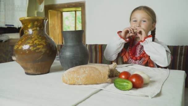 A gyermek eszik az asztalnál ül — Stock videók