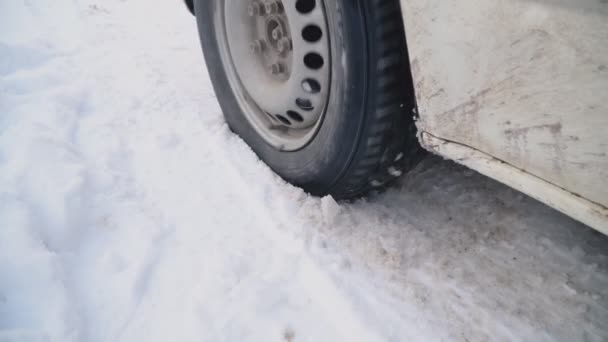Колесо автомобиля на зимней дороге — стоковое видео