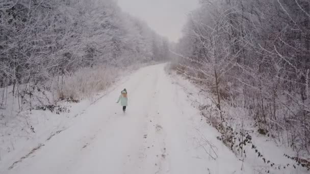 Het kind loopt langs de weg van het bos — Stockvideo