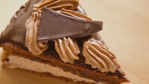 Een plakje chocoladetaart in een draaiende witte plaat — Stockvideo