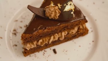 Dönen beyaz tabakta bir dilim çikolatalı pasta.