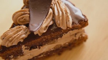 Dönen beyaz tabakta bir dilim çikolatalı pasta.