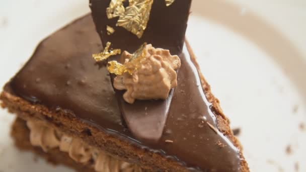 Una rebanada de pastel de chocolate en un plato blanco giratorio — Vídeos de Stock