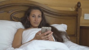 Bir telefonla yatakta kadın