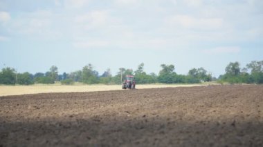 Kırmızı traktör tarlayı sürüyor