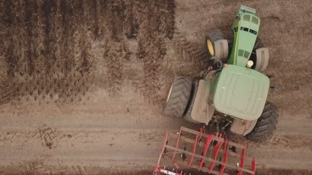 Zöld traktor szántja a földet — Stock videók