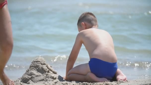 I bambini costruiscono un castello di sabbia — Video Stock