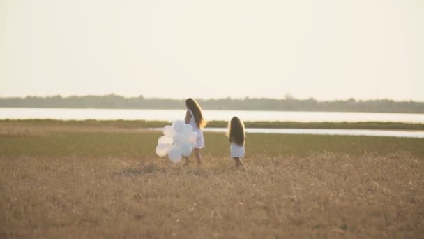 Äiti tytär ja valkoinen ilmapalloja — kuvapankkivideo