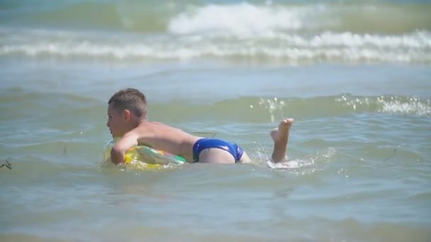 Ein Junge mit einem Kreis schwimmt — Stockvideo