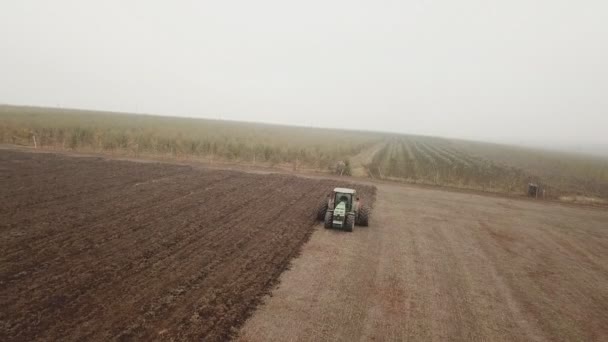 Egy nagy traktor szántja a mezőt — Stock videók