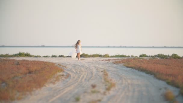 Девушка с воздушными шарами на песчаной дороге — стоковое видео