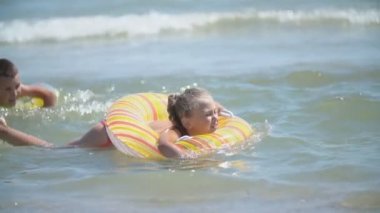 Çocuklar denizde yüzer.