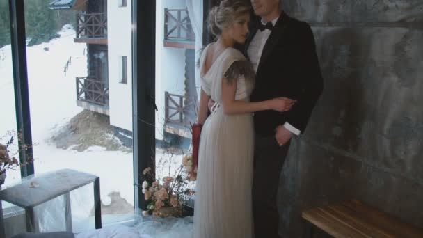 Νεαρό ζευγάρι στέκεται κοντά στο παράθυρο — Αρχείο Βίντεο