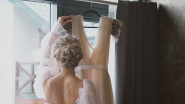 Kız elbisesini inceliyor.