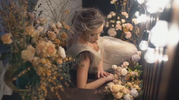 Το κορίτσι βρίσκεται στις συγκεντρώσεις ανάμεσα στα λουλούδια. — Αρχείο Βίντεο