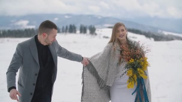 Couple walking on a snowy lawn — Stock Video