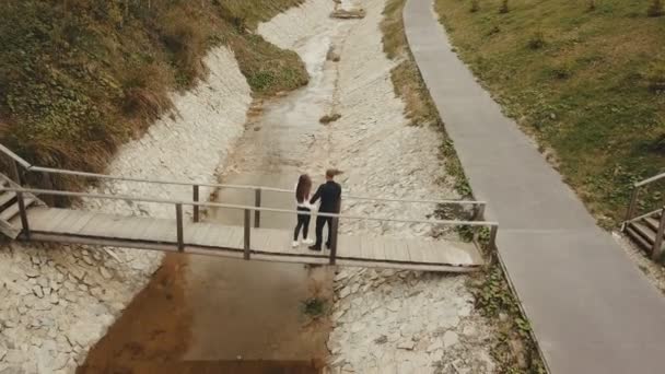 Casal passa sobre a ponte — Vídeo de Stock