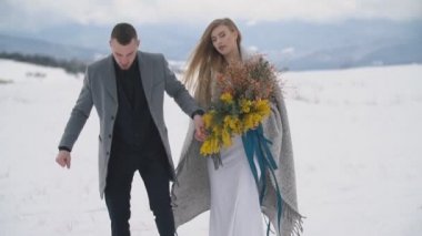 Karlı çimlerde yürüyen çift
