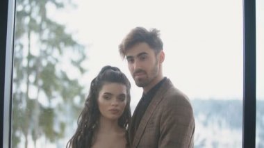 Çift balkonda sarılıyor.