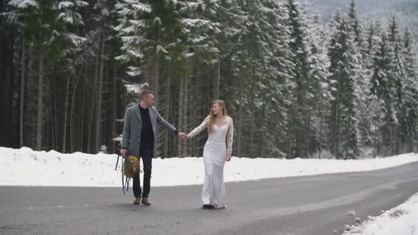 Casal andando em uma estrada em uma floresta — Vídeo de Stock