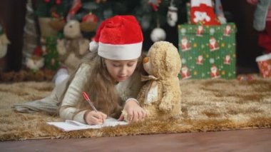 Çocuk Noel Baba 'ya mektup yazıyor.