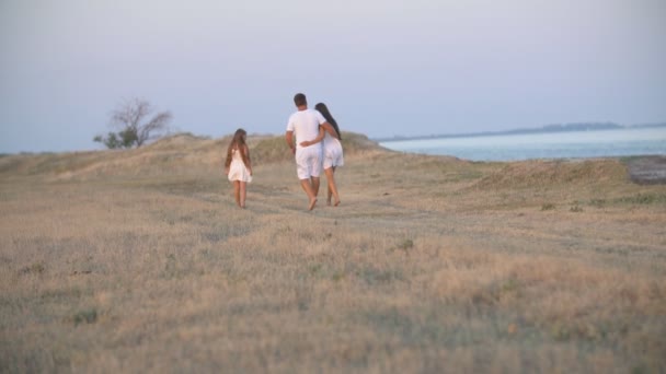 Familie van drie wandelen in de natuur — Stockvideo