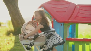 Çocuk bebek arabasıyla oynuyor.