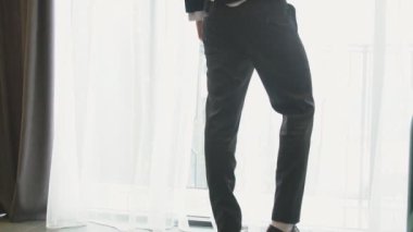 Bir adam durur ve pencereden dışarı bakar.