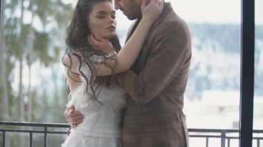 Çift balkonda sarılıyor.