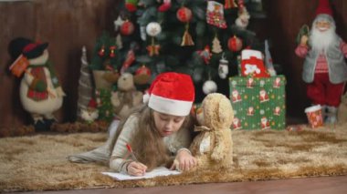 Çocuk Noel Baba 'ya mektup yazıyor.