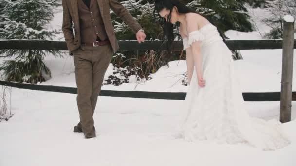 Débilmente vestido pareja cabalgando en la nieve — Vídeos de Stock