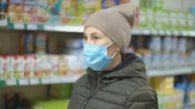 Tıbbi maskeli kadın meyve suyunu seçer.