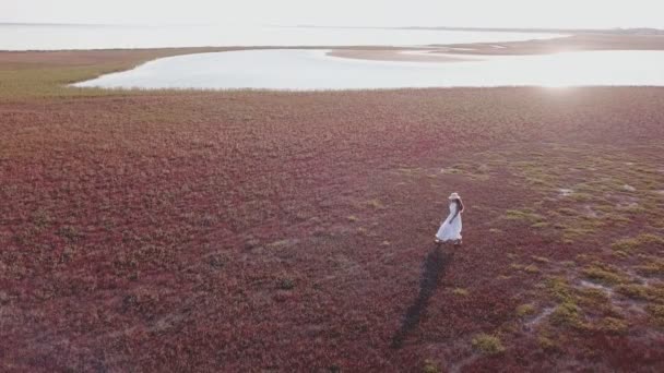 Fille dans une robe blanche marchant le long de la rive — Video