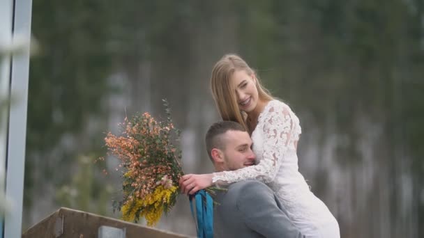 Hombre sostiene a su esposa en sus brazos — Vídeo de stock