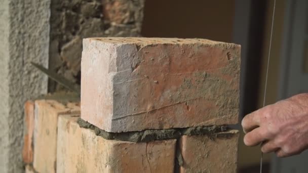 Bauarbeiter misst die Ebenheit der Mauer — Stockvideo