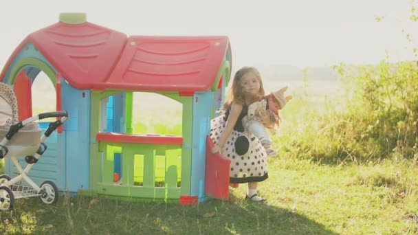 Niño juega con una muñeca — Vídeo de stock