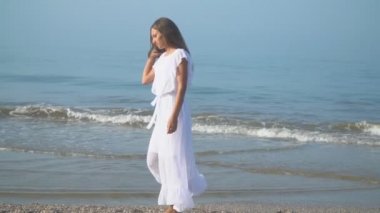 Kız deniz kıyısında yürüyor