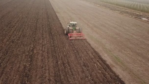 Traktor plogar ett fält, antenn vy — Stockvideo