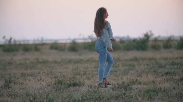 Meisje in jeans kleding wandelen in de natuur — Stockvideo