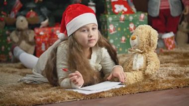 Çocuk Noel Baba 'ya mektup yazıyor.