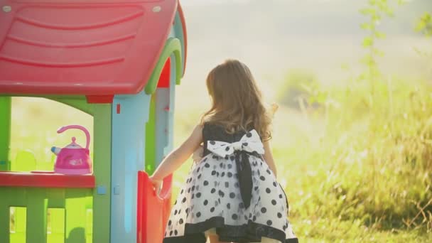 Маленькая девочка играет со своим домом — стоковое видео