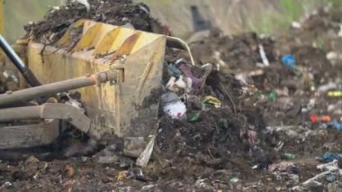 Çöpleri iten buldozer küreği