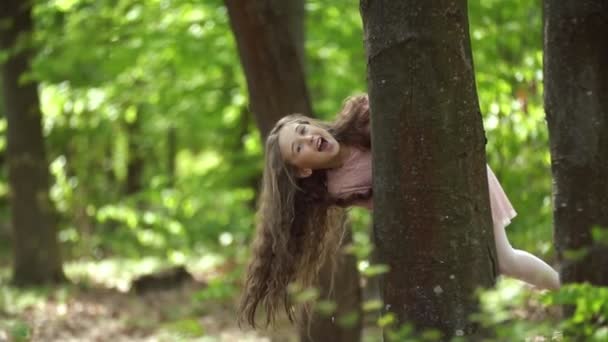 Girl hiding behind a tree — Stock Video