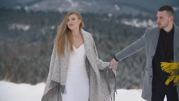 Pareja caminando sobre un césped cubierto de nieve — Vídeos de Stock