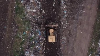 Buldozer bir yığın çöp topluyor.