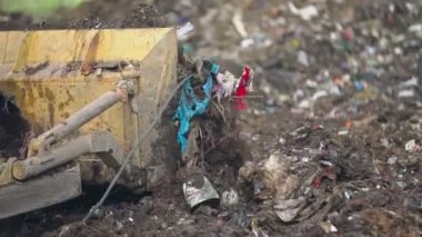 Çöpleri iten buldozer küreği